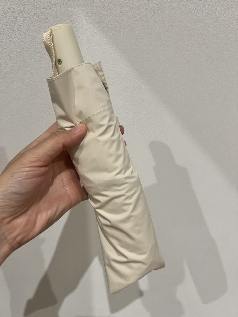 白い折りたたみ日傘を収納ケースに入れた状態