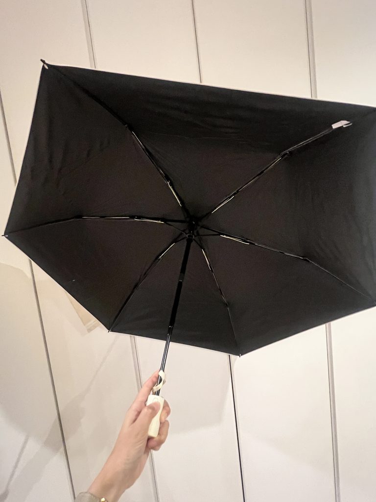白い折りたたみ日傘を開いた内側の黒い生地